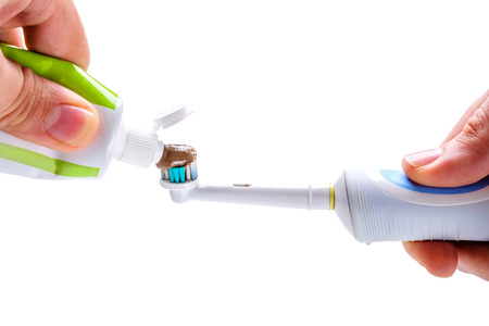 herbal toothpaste on Electric toothbrush in hand is included isolated on a white backgroundの写真素材