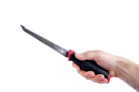 man's hand hold old saw with black and red handle isolated on white background close-upの写真素材
