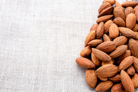 handful of almonds close up on linen material copy space for textの写真素材