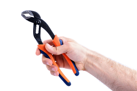 man's hand hold adjustable wrench with orange and blue handle isolated on white background close-upの写真素材