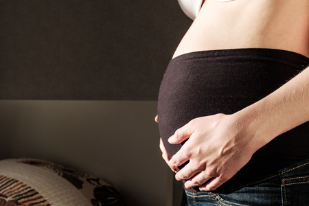 pregnant woman tummy, dressed in maternity jeans, lose upの写真素材
