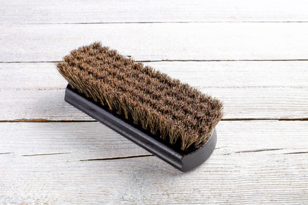 dark brown wooden shoe shine polish brush on white wooden background, close upの写真素材