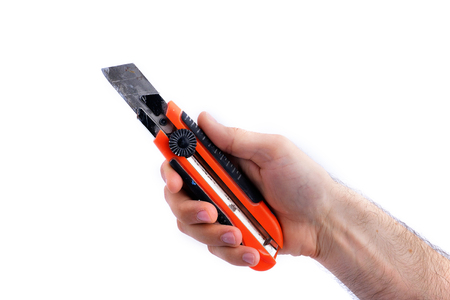 man's hand hold used paper knife with black and red handle isolated on white background close-up
