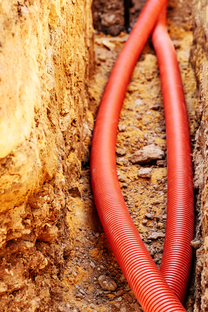 new corrugated PVC pipe for laying electric cable laid in the trench , sandy soilの写真素材