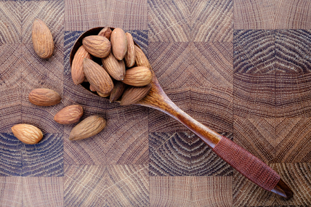 wooden spoon with nuts snack salted almonds on wooden chef's Board closeup top viewの写真素材