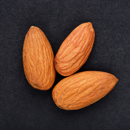 almonds macro on on black slate background top viewの写真素材