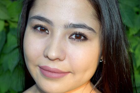 portrait of a beautiful young Asian girl close-up with brown eyesの写真素材