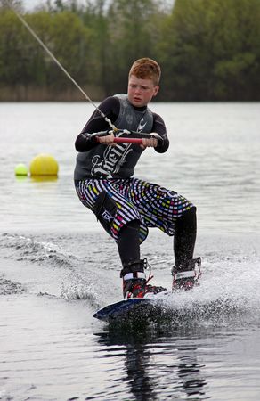 A boy Wake Boarder / wakeboarding at the British Disabled Water Ski-ing Association BDWSA Heron Lake, Wraysbury, UK April 25th 2010のeditorial素材