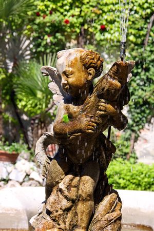 Italian Eros water fountain in a gardenの写真素材