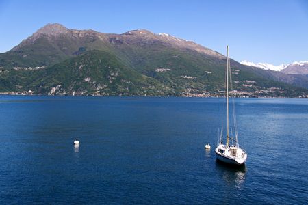A sailing yacht on Lake Como, Italy with Treviso mountainsの写真素材