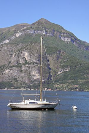 Scene of tree covered mountain, sailing yacht and Lake Como in Italyの写真素材