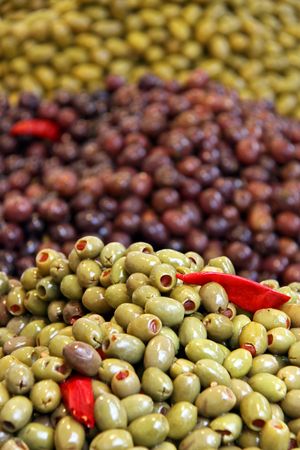 Green and black olives and sun dried tomatoes at a marketの写真素材