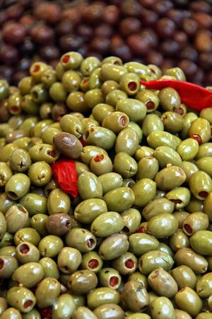 Green and black olives and sun dried tomatoes at a marketの写真素材