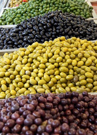 Green and black olives at a marketの写真素材