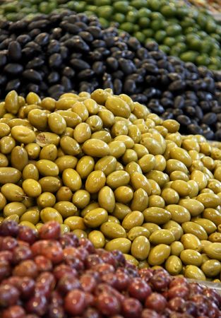 Green and black olives at a marketの写真素材