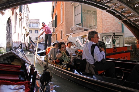 Venice, Italy, 21/5/10 Italian gondolier and tourist passengers in a gondola in a Venetian canalのeditorial素材