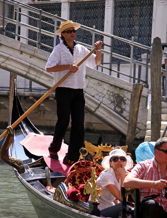 Venice, Italy, 21/5/10 Italian gondolier and tourist passengers in a gondola in a Venetian canalのeditorial素材
