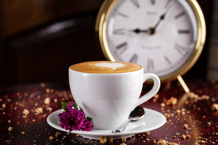coffee cappuccino in a white cup with an art drawing in the form of a heart on the dervevyano table,...