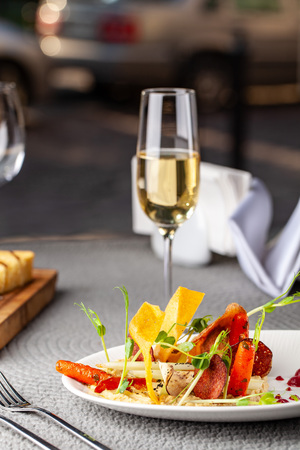 The concept of high European cuisine, molecular cuisine. Dish in an expensive restaurant of vegetables from the garden. expensive table server, on the table instruments and a glass of champagne.の写真素材