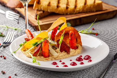 The concept of high European cuisine, molecular cuisine. Dish in an expensive restaurant of vegetables from the garden. expensive table server, on the table instruments and a glass of champagne.の写真素材