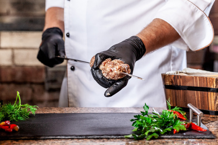 The concept of Georgian cuisine. Recipe for cooking meat lyulya kebab in the dough on the grill. Chef puts meat on a skewer.の写真素材