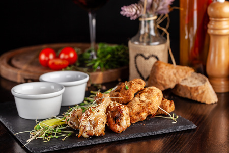The concept of Italian cuisine. Snack to beer. Glazed chicken legs and chicken wings, breaded....