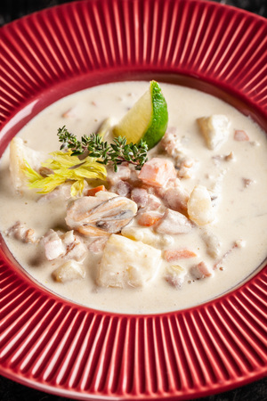 The concept of American cuisine. Clam chowder potato soup with sea food, mussels, salmon. Fish broth soup with milk. Serving dishes in the restaurant. copy spaceの写真素材