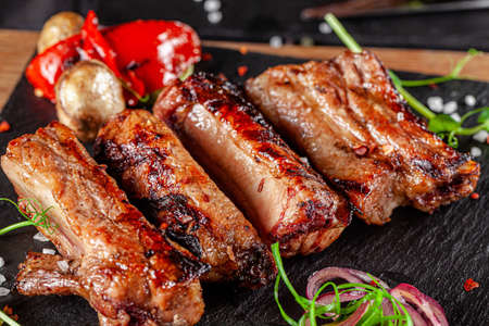 American cuisine. Fried pork ribs in josper. Serving food in a restaurant on a wooden board.の写真素材