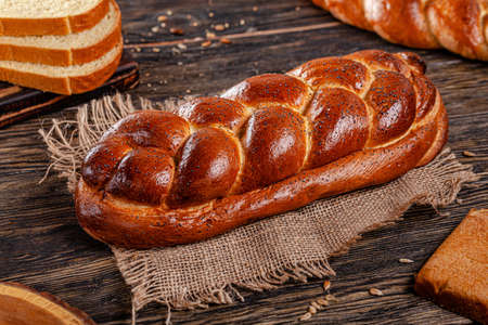 Assorted bread for catalan shooting. Long loaf, buns, baguette, pigtail, shaped. Bread on a wooden...