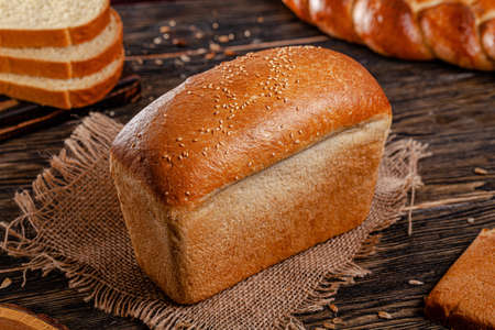 Assorted bread for catalan shooting. Long loaf, buns, baguette, pigtail, shaped. Bread on a wooden background.の写真素材