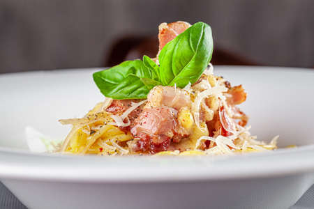 Italian Cuisine. Carbanara pasta with bacon and parmesan. Beautiful serving dish in a restaurant in a white plate. background image, copy space textの写真素材