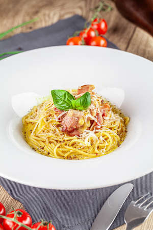 Italian Cuisine. Carbanara pasta with bacon and parmesan. Beautiful serving dish in a restaurant in a white plate. background image, copy space textの写真素材
