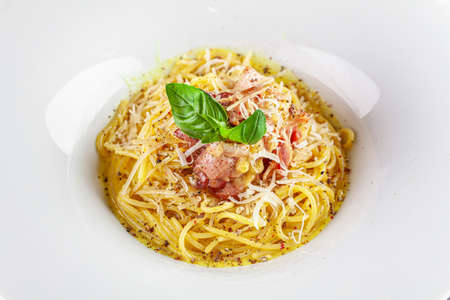 Italian Cuisine. Carbanara pasta with bacon and parmesan. Beautiful serving dish in a restaurant in a white plate. background image, copy space textの写真素材