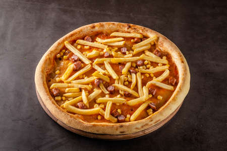 Italian Cuisine. Thin Oktoberfest pizza with french fries, hunting sausages and corn. Background image. copy spaceの写真素材