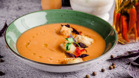Spanish cuisine. Cold summer tomato soup gazpacho with croutons and basil.の写真素材