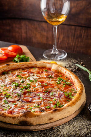 Italian Cuisine. Thin pizza with bacon, red onion, green onion and mushrooms in tomato sauce. Background image. copy spaceの写真素材