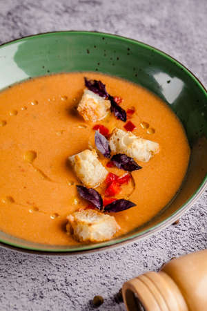 Spanish cuisine. Cold summer tomato soup gazpacho with croutons and basil.の写真素材