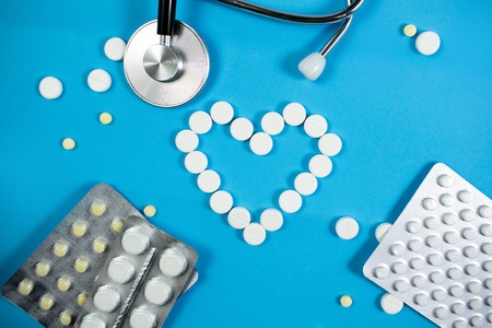 Medical background with multi-colored packs of pills. ?oncept pharmacy, clinic, drugs, headache medicine. Image on illness, flu, treatment. White heart shaped pillsの写真素材