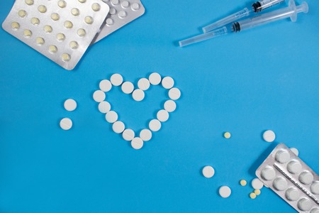 Medical background with multi-colored packs of pills. ?oncept pharmacy, clinic, drugs, headache medicine. Image on illness, flu, treatment. White heart shaped pillsの写真素材