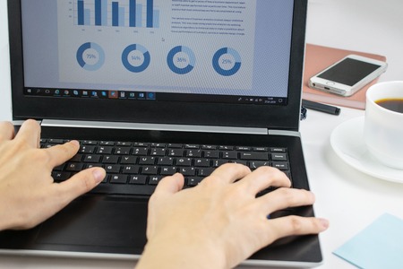 Minimalistic workplace concept, with a laptop, pen and business work records on a white background. Image of business plan, startup. Close up image.の写真素材