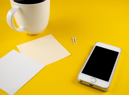 Minimalistic workplace concept, with a smartphone, pen and business work records on a dark background. Image digital, marketing, design agency. Top view. Flat lay styleの写真素材