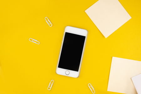 Minimalistic workplace concept, with a smartphone, pen and business work records on a dark background. Image digital, marketing, design agency. Top view. Flat lay styleの写真素材