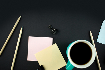 Minimalistic workplace concept, with a smartphone, pen and business work records on a dark background. Image digital, marketing, design agency. Top view. Flat lay styleの写真素材