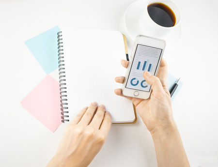 Minimalistic workplace concept, with a stationery, pen and business work records on a white background. Image of business plan, startup. Top view. Flat lay styleの写真素材