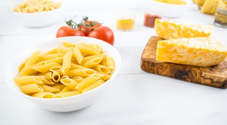 Various types of pasta on a white wooden table. Italian cuisine concept, food ingredients. Close up view.の写真素材