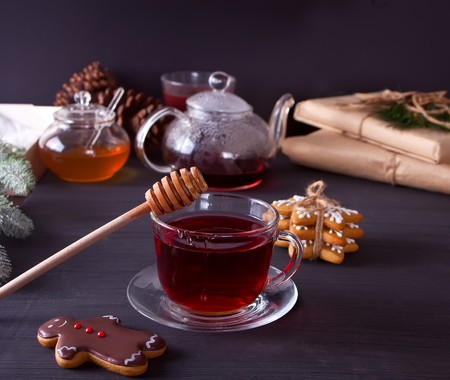 Homemade Christmas cookies funny gingerbread man and snowflakes , honey and cup of tea on the wooden table.の写真素材