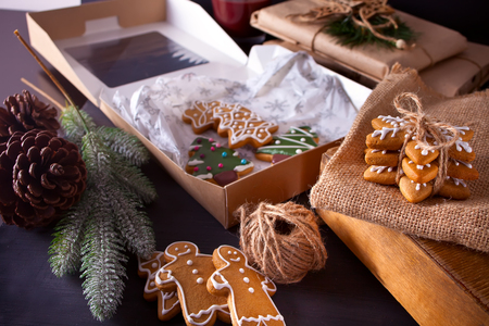Christmas cookies snowflakes, gingerbread man, tree and gifts box on the wooden tableの写真素材
