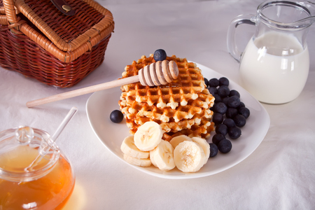 Cup of coffee and waffles with bananas, blueberries and honey. Morning breakfast.の写真素材
