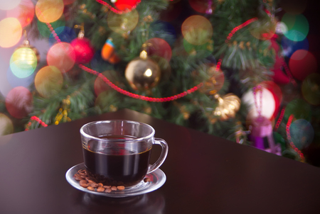 Cup of coffee on the wooden table on the Christmas backgroundの写真素材
