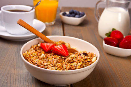 Breakfast with muesli, strawberries, juice, milk on a white backgroundの写真素材